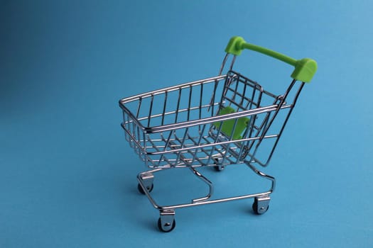 shopping cart on a blue background with a copyspace. purchases. business. Buyer demand. shop. Buyers.