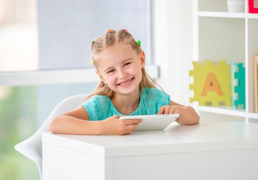 School girl using tablet for study sitting in classroom
