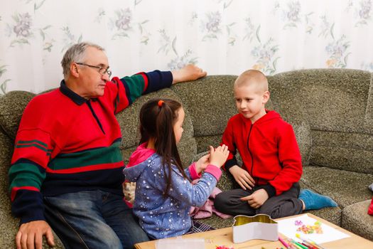 grandfather spends time with grandchildren in the living room