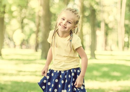 cute little girl laughing in the morning park. blurred background