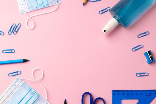 School stationery items and medical face mask, top view