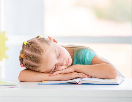 Cute school girl sleeping right on open book