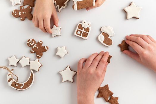 Children are getting ready for Christmas. Gingerbread cookies in children's hands. Top view.