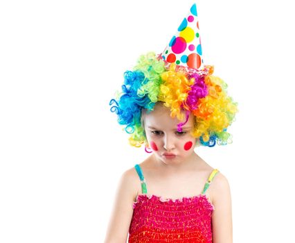 Little girl in bright colourful wig puckers her lips while looking at something, isolated on white backgroung