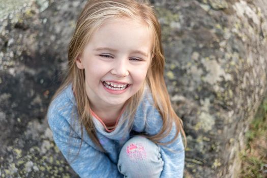 Portrait of happy blonde small girl with beautiful blue eyes.