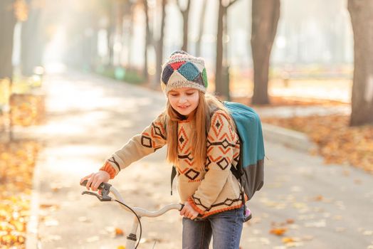 Bicycle girl with backpack riding to school