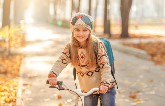 Bicycle girl with backpack riding to school