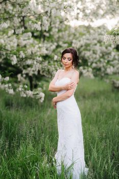 bride in a white dress with a large spring bouquet in a green forest