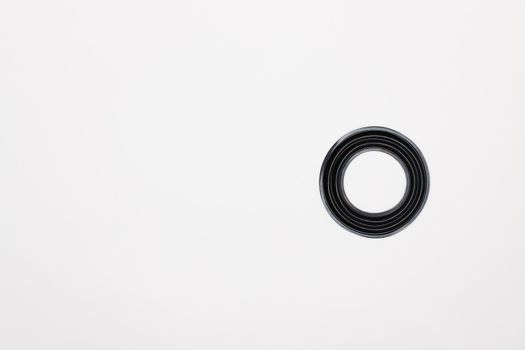 A rubber ring - a gasket, an oil seal for repairing a car brake caliper on a plane. Set of spare parts for car brake repair. Details on white background, copy space available. UHD 4K.