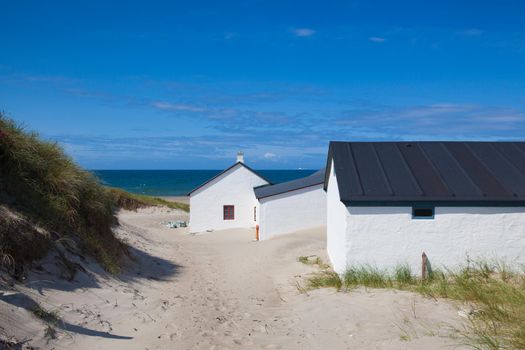 White fishing buildings on the beach in Stenbjerg. It is a fishing village on the former island of Thy in the northwest of Jutland, Denmark.