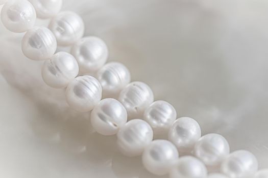 Nature white string of pearls on marble background in soft focus, with highlights