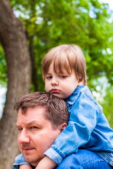 A male father spends time with his young son. Family walks in nature. The joy of being together.