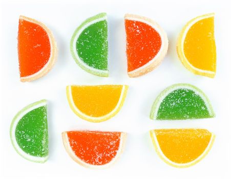 Multicolored marmalade citrus slices in sugar on a white background.