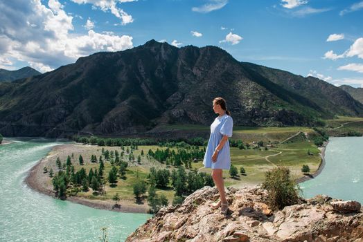 Woman in blue dress on the confluence of two rivers Katun and Chuya in Altai mountains, beauty summer day