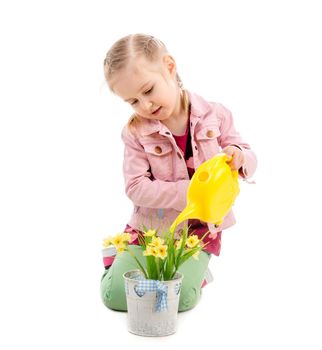 Adorable kid watering flowers with yellow watering can, wearing pink jacket, isolated on white background