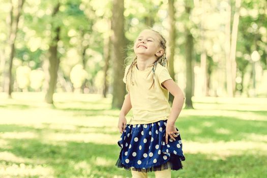 cute little girl laughing in the morning park. blurred background