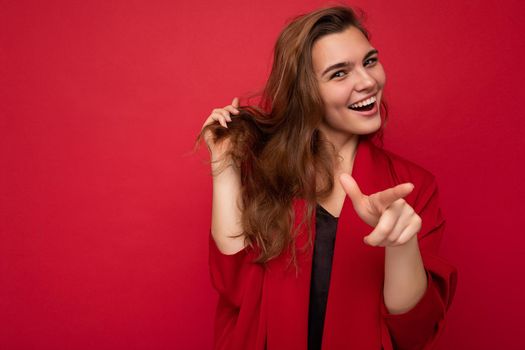 Photo portrait of beautiful happy funny young brunette woman in stylish red cardigan. Sexy carefree female person posing isolated on red background. Positive model shows sincere emotions.