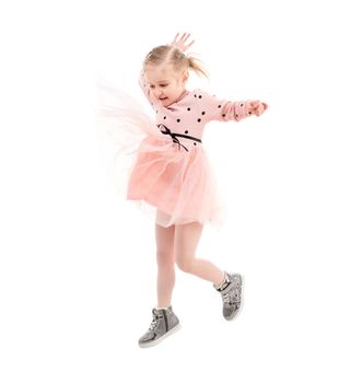 Funny girl jumping high, expressing herself, pinkish skirt jumps up, laughing and enjoying time, isolated