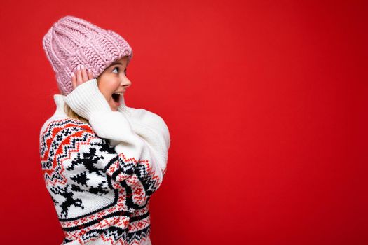 Side-profile photo of pretty shocked surprised happy young blonde woman standing isolated over colourful background wall wearing everyday trendy clothes looking to the side. Copy space