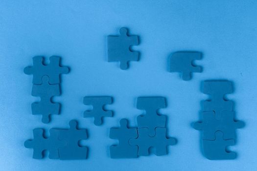 Puzzle pieces on classic blue background, top view. Close up.