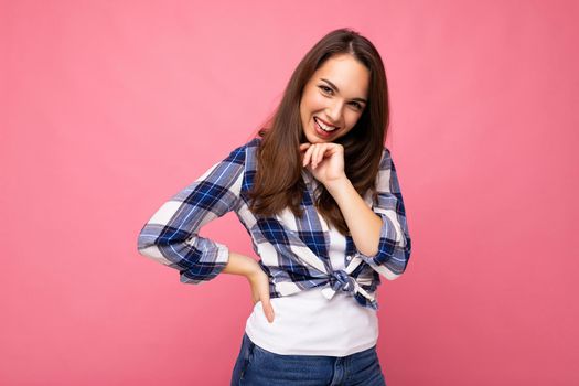 Portrait of positive cheerful fashionable woman in hipster outfit isolated on pink background with copy space.