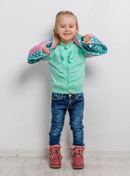 cheerful little girl in turquoise sweater with