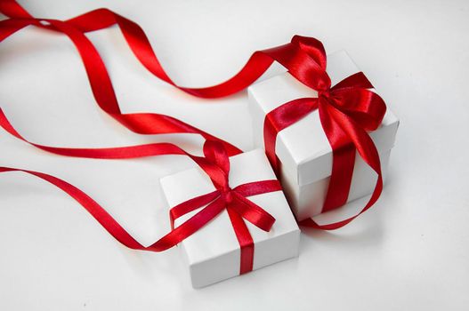 Christmas Gift's in White Box with Red Ribbon on Light Background. New Year Holiday Composition