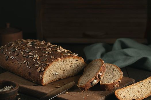 Sliced Homemade Whole Grain Bread with Seeds on a Cutting Board.