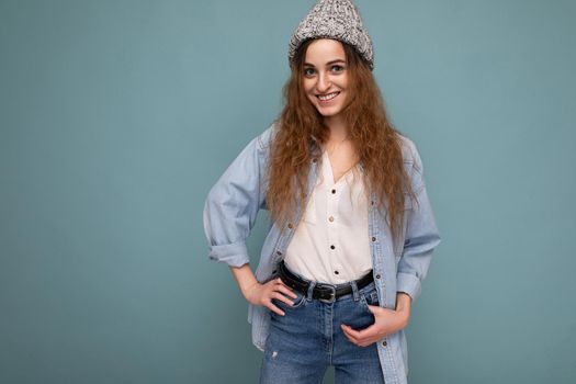 Beautiful positive happy young dark blonde woman isolated over colourful background wall wearing casual stylish clothes feeling sincere emotions looking at camera. Copy space