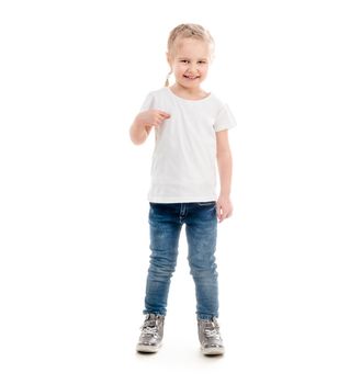 Tiny girl standing pointing at herself, wearing t-shirt, jeans and shity trainers, isolated