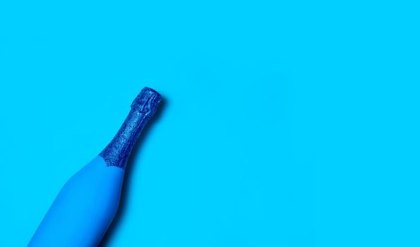 Festive Minimalistic Champagne Bottle on Blue Background. Creative Concept. Classic Blue - Color of the year 2020. Top View. Copy Space For Your Text