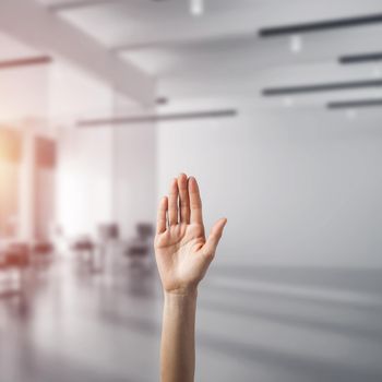 Close of woman hand touching screen with palm and office at background