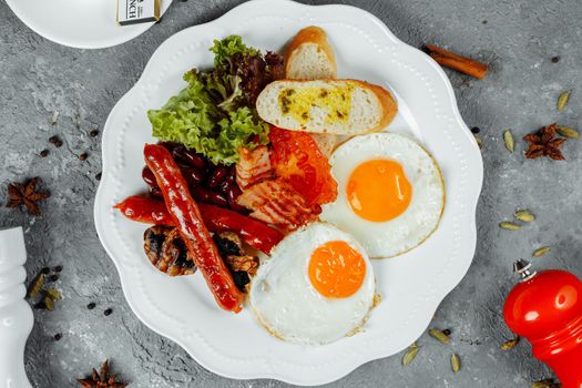 Fried breakfast with bacon, sausages and baked beans.