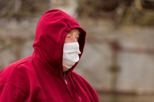 Portrait of an elderly European man with a short haircut in a protective safe medical mask, close-up.