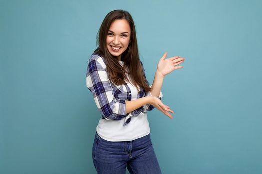 Close up photo of positive happy amazing cute nice charming young woman holding hands and showing advertisement wearing casual clothes isolated over background with copy space.