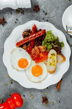 Fried breakfast with bacon, sausages and baked beans.