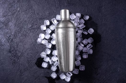 Chrome Bar Shaker With Ice on Dark Stone Table. Concept Of Cold Summer Drinks. Top View Flat Lay. Copy Space For Your Text.