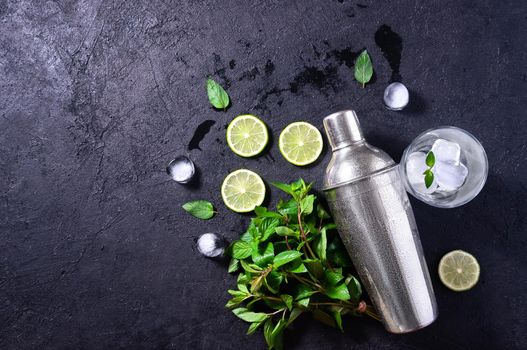 Mojito Cocktail Making. Mint, Lime, Ice, Glass and Bar Shaker on Dark Stone Table. Copy Space For Your Text.