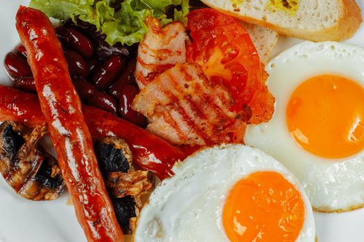 Fried breakfast with bacon, sausages and baked beans.