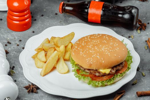 hamburger with fries and salad on the plate.