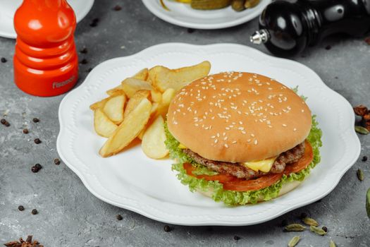 hamburger with fries and salad on the plate.