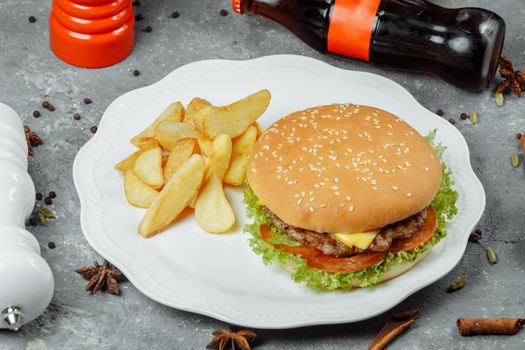 hamburger with fries and salad on the plate.