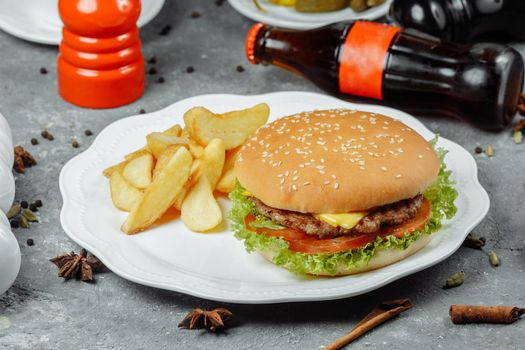 hamburger with fries and salad on the plate.