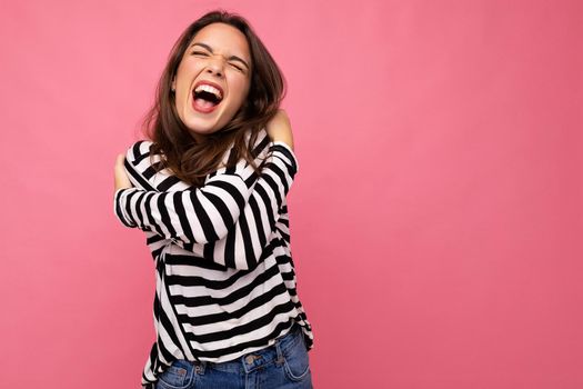 Photo shot of cute attractive pretty young emotional mad brunette woman wearing casual striped longsleeve isolated over colorful background with copy space and shouting.
