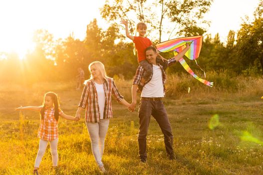 Happy family walking in field and looking at sunset