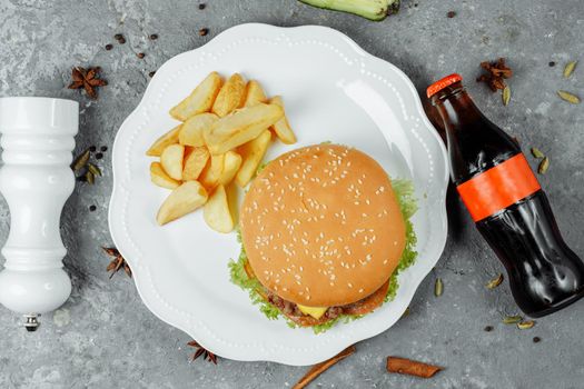 hamburger with fries and salad on the plate.