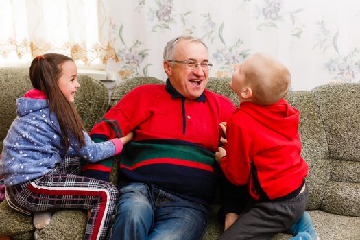 grandfather spends time with grandchildren in the living room