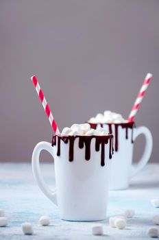 Christmas Hot Drink. White Cups of Cocoa or Chocolate with Marshmallows on Light Background with Christmas Decorations.