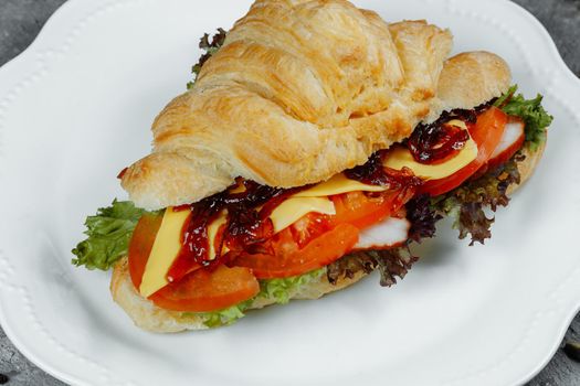 Delicious ham and cheddar cheese croissant with salad.