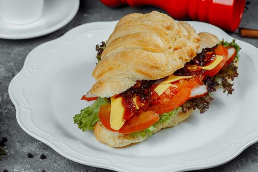 Delicious ham and cheddar cheese croissant with salad.